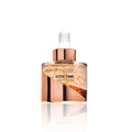 Skincare serum bottle with rose gold cap and clear container on a white background