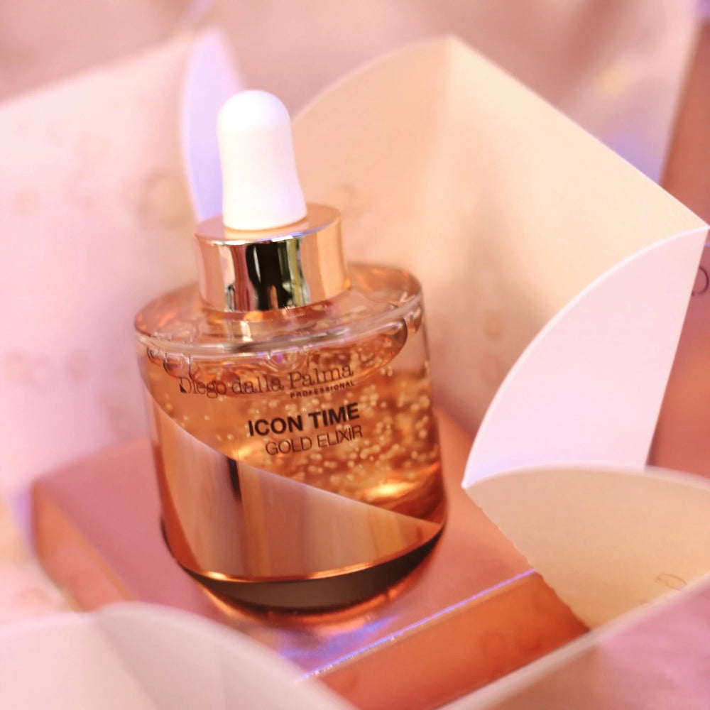 Cosmetic bottle labeled 'Icon Time Gold Elixir' by Diego Dalla Palma on a soft pink background.