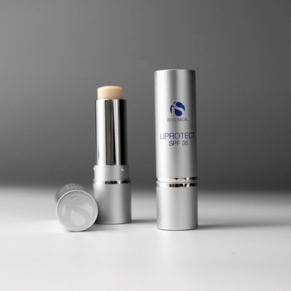 Silver cosmetic stick with applicator and packaging on a gray background