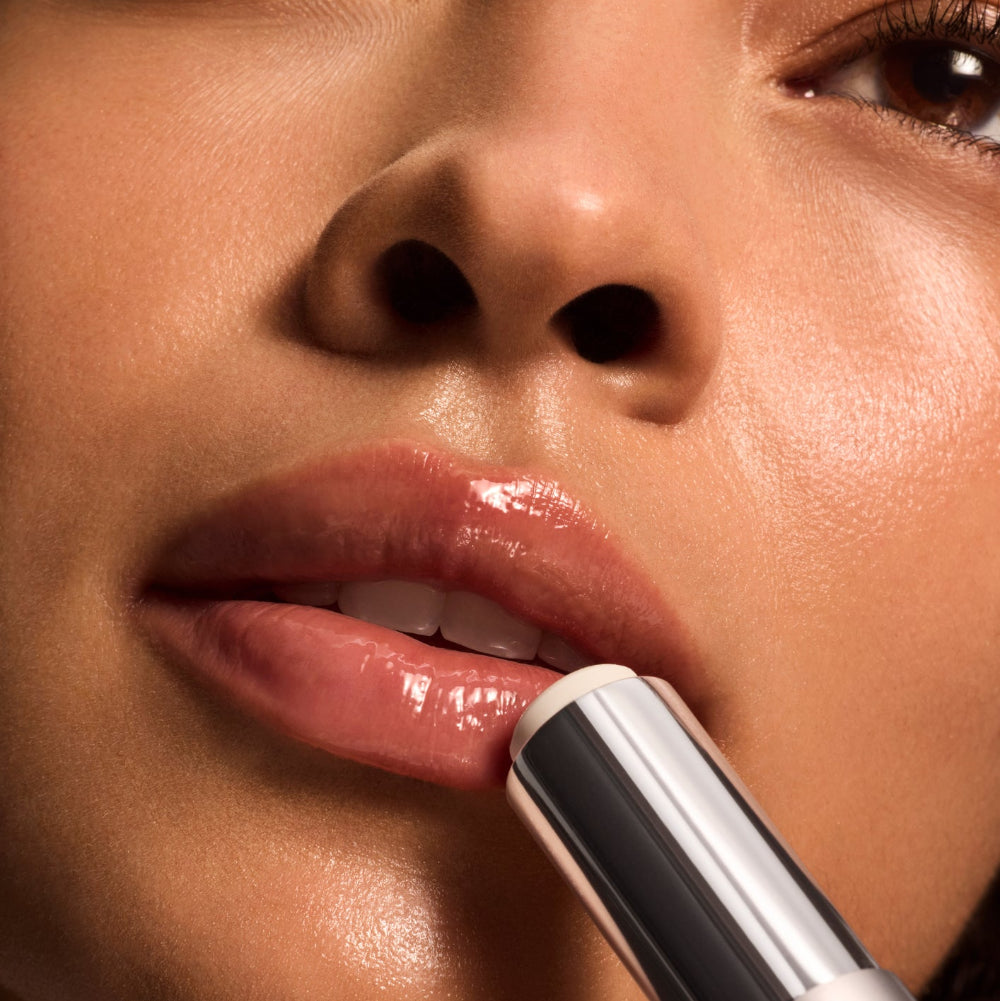 Close-up of a person applying lipstick with a focus on the lips and lipstick.