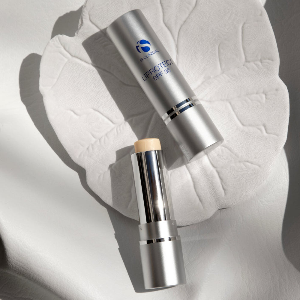 Two skincare products on a textured white surface