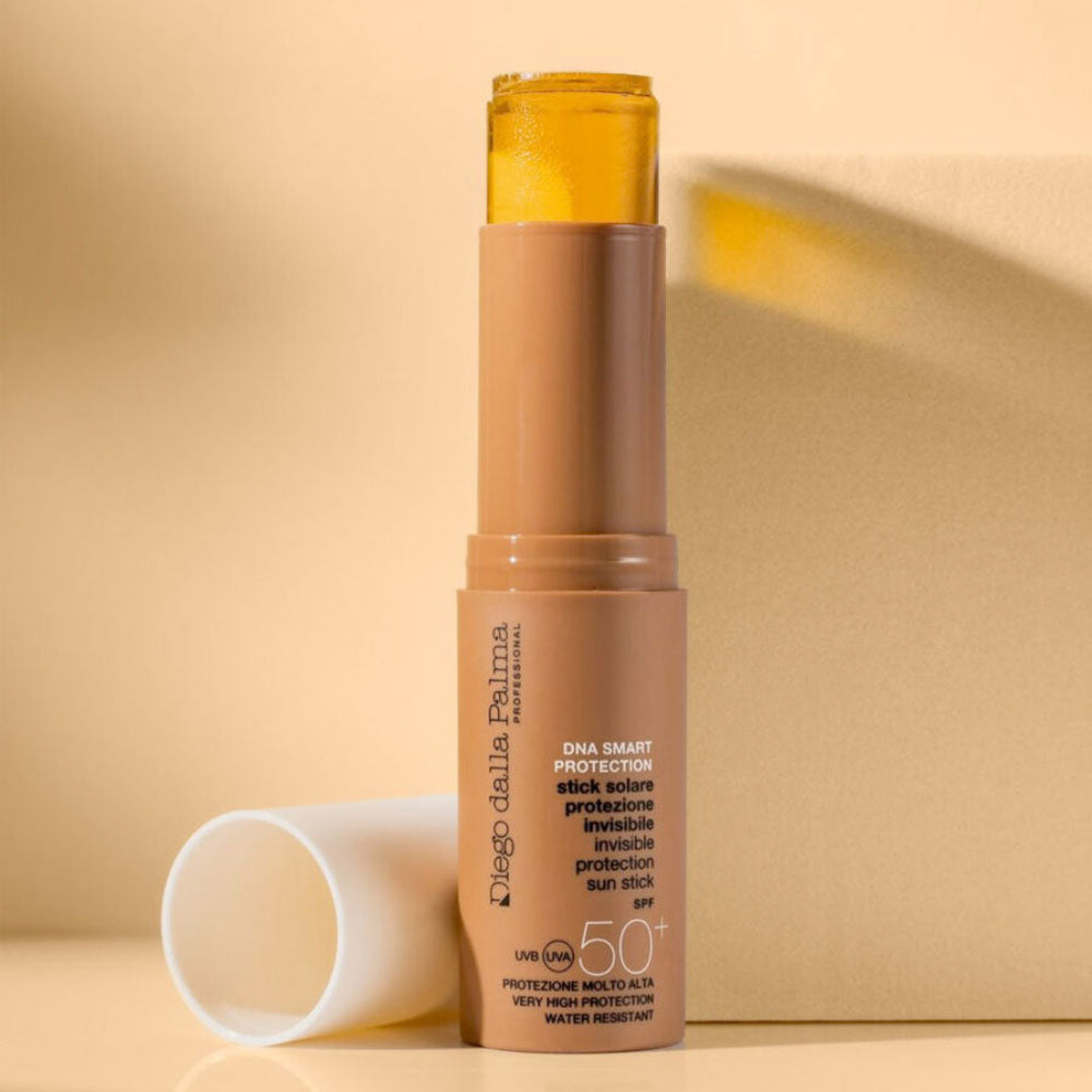 Sunscreen stick with yellow cap on a beige background