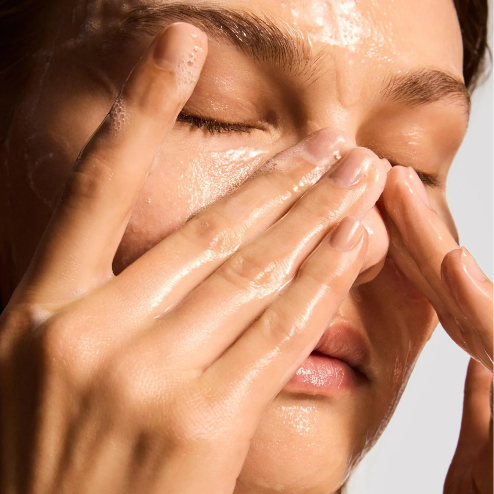 Person applying a skincare product to their face with hands