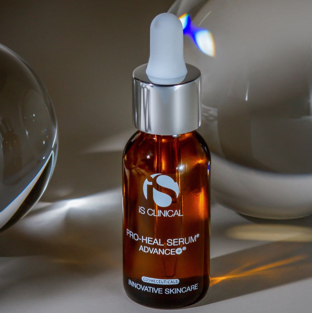 Brown serum bottle with dropper labeled 'iS Clinical Pro-Heal Serum Advance' on a neutral background.