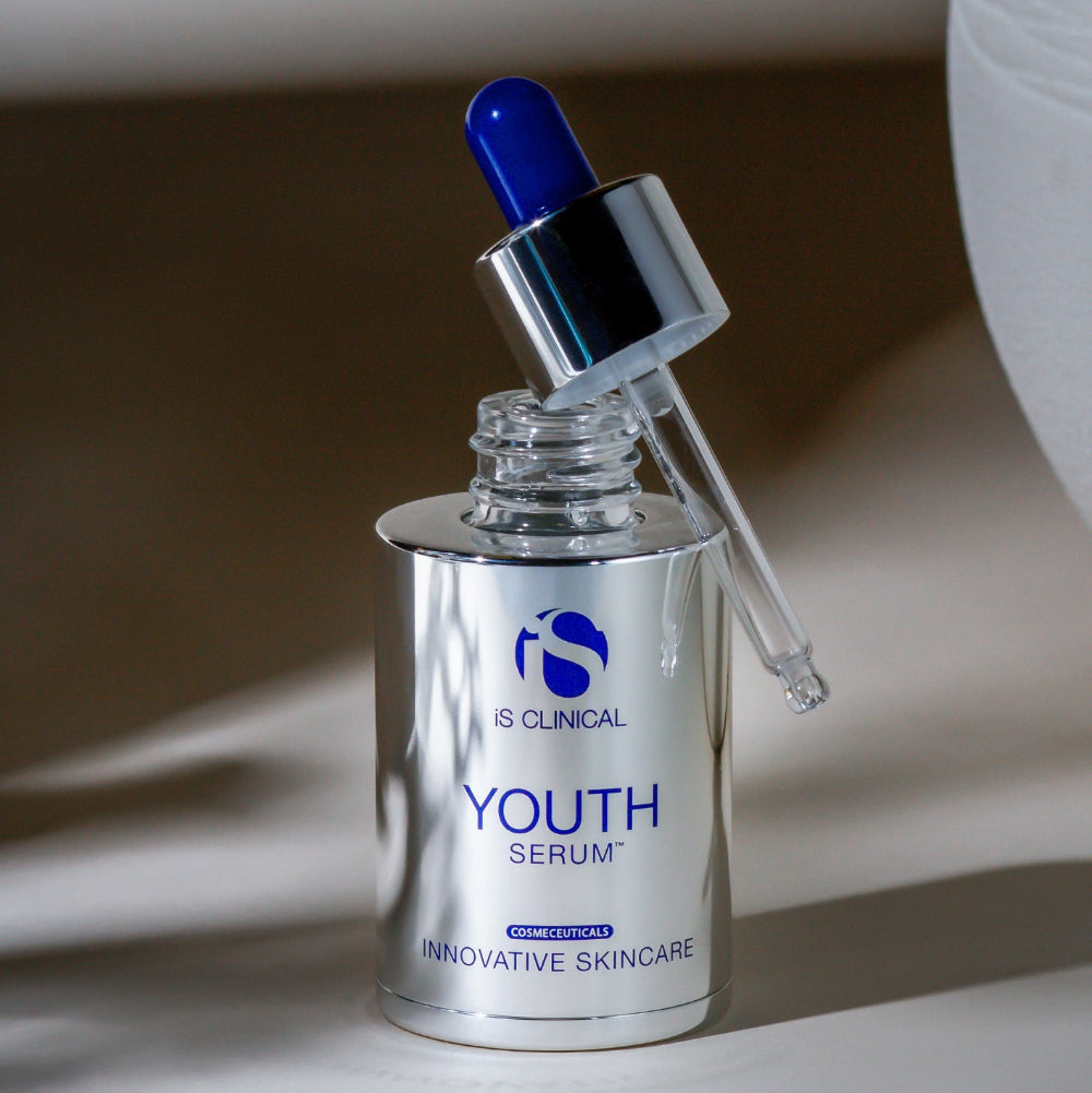 IS Clinical Youth Serum bottle with dropper on a neutral background
