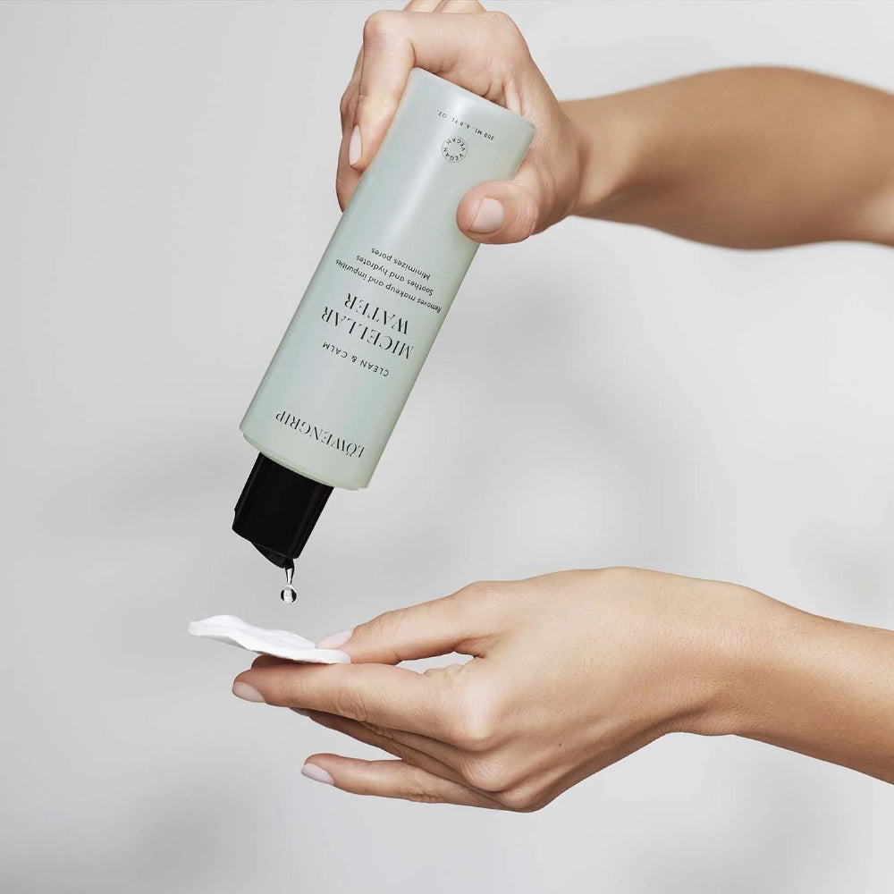 Hand holding a skincare product with a white background