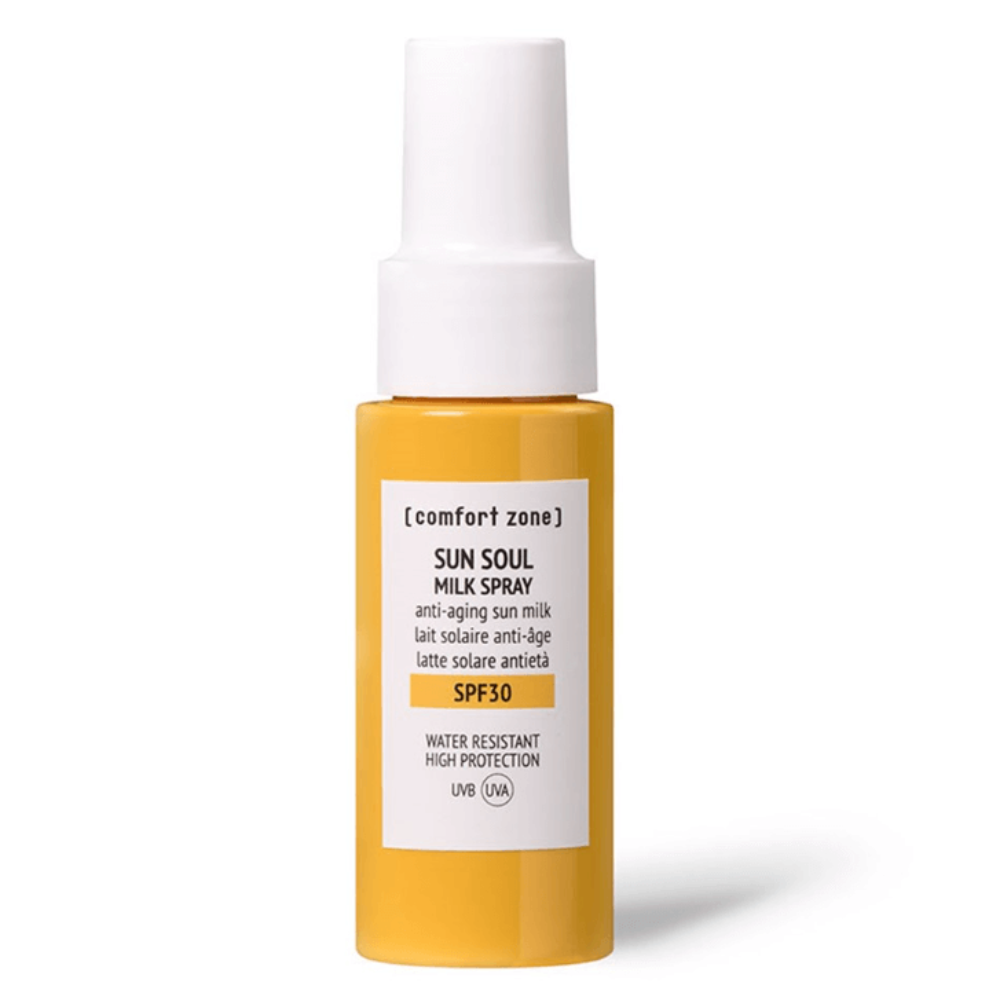 Sunscreen spray bottle with yellow body and white cap on a white background
